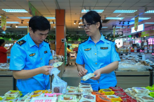 图为执法人员检查散装月饼包装。.JPG